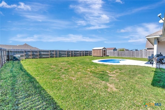 view of yard with an outbuilding, a storage unit, a fenced backyard, and a patio area