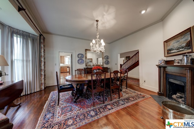 dining area with a notable chandelier, dark hardwood / wood-style floors, and crown molding