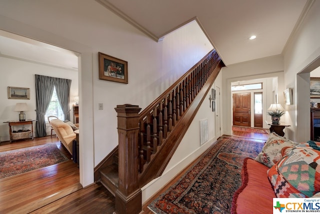 staircase featuring hardwood / wood-style floors and ornamental molding