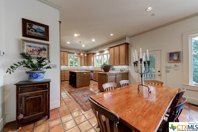 dining space with light tile patterned floors, an inviting chandelier, and crown molding