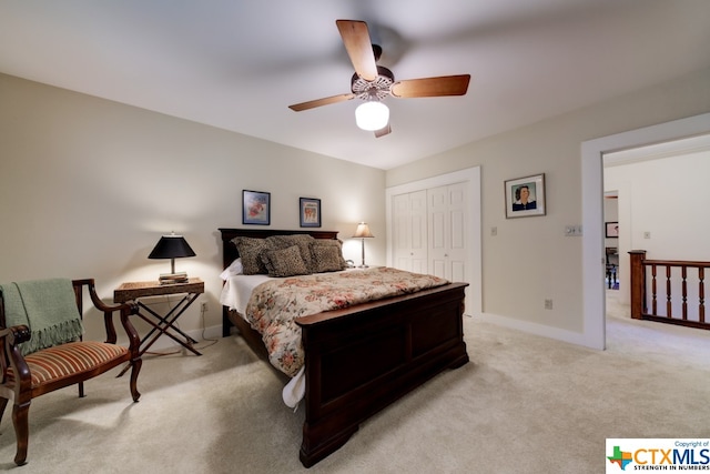 bedroom with ceiling fan, a closet, and light colored carpet