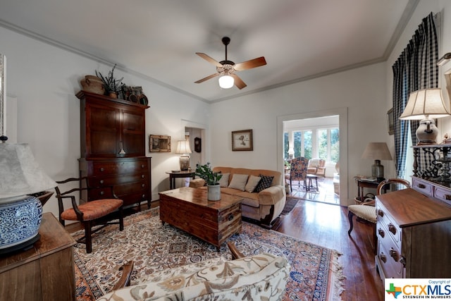 living room featuring ceiling fan, dark hardwood / wood-style flooring, and crown molding