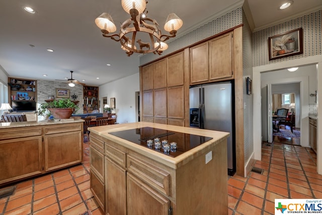 kitchen featuring a center island, stainless steel fridge, black electric cooktop, ceiling fan with notable chandelier, and ornamental molding