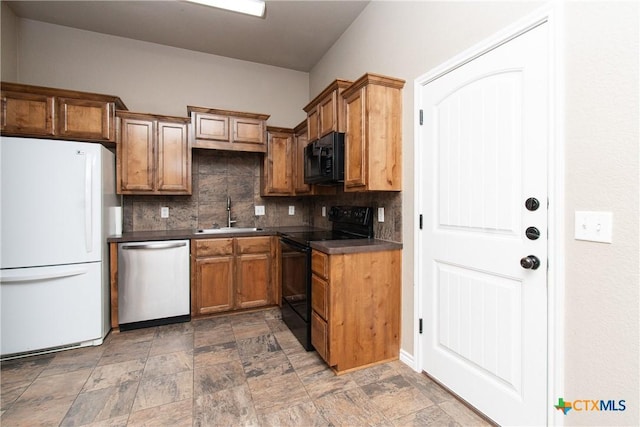 607 Sladecek Dr, Killeen, TX 76542 - kitchen with black appliances, a sink, decorative backsplash, dark countertops, and stone finish flooring