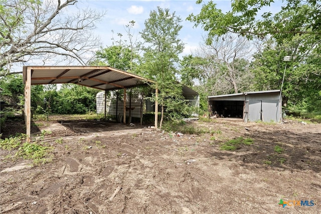 view of yard with an outdoor structure and a carport