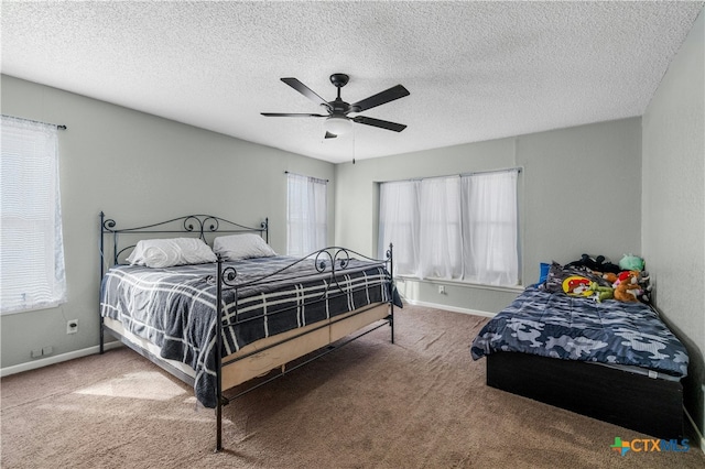 carpeted bedroom featuring ceiling fan and a textured ceiling