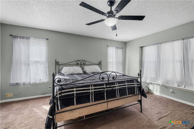 bedroom with ceiling fan, carpet, and a textured ceiling