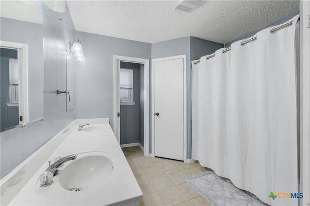 bathroom featuring vanity, a shower with curtain, a textured ceiling, and tile patterned floors