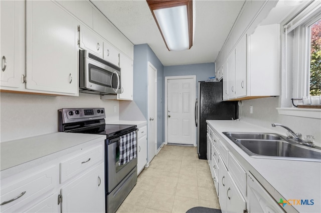 kitchen with black appliances, white cabinetry, sink, and light tile patterned floors