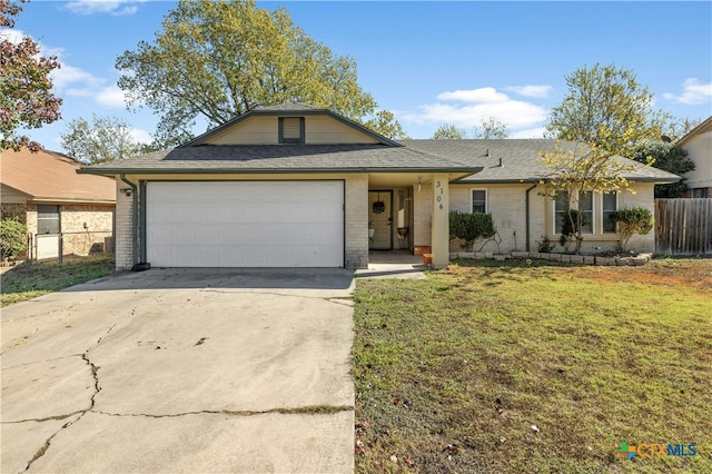 ranch-style house featuring a garage and a front lawn