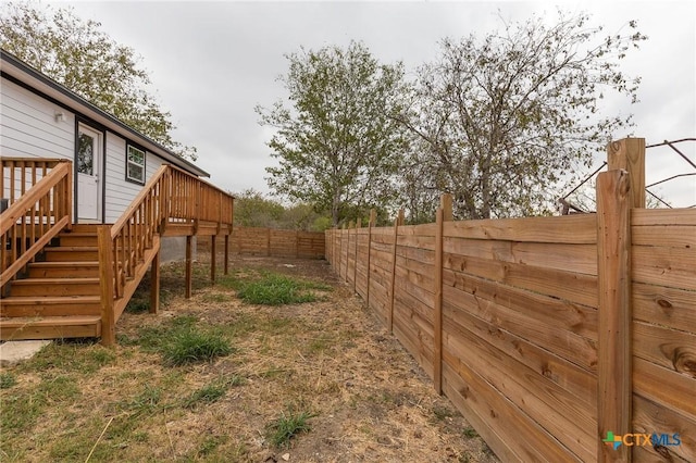 1123 Ainsworth St, Gonzales, TX 78629 - fenced backyard featuring a deck and stairway
