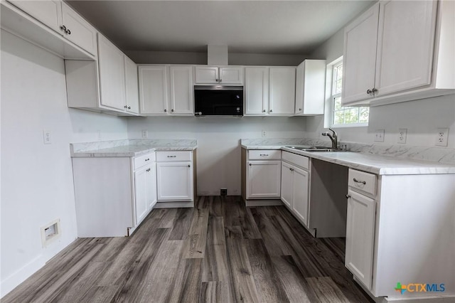 1123 Ainsworth St, Gonzales, TX 78629 - kitchen with dark wood finished floors and white cabinetry