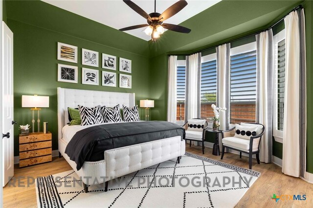 bedroom with ceiling fan, baseboards, and wood finished floors