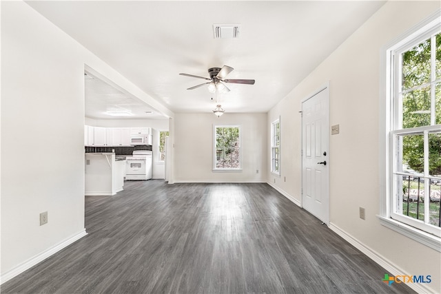 unfurnished living room featuring ceiling fan and dark hardwood / wood-style floors