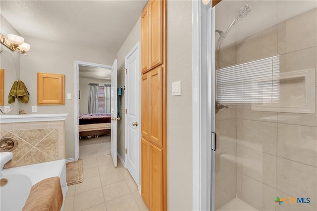 ensuite bathroom with connected bathroom, a bathtub, a shower stall, and tile patterned flooring