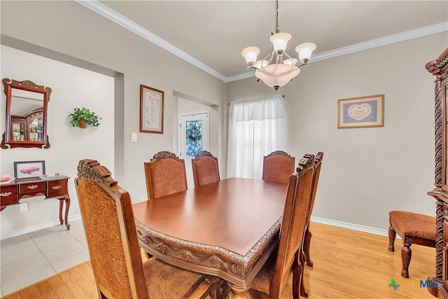 dining space with crown molding, light wood-style flooring, baseboards, and a chandelier