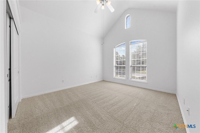 unfurnished bedroom with carpet floors, multiple windows, and high vaulted ceiling