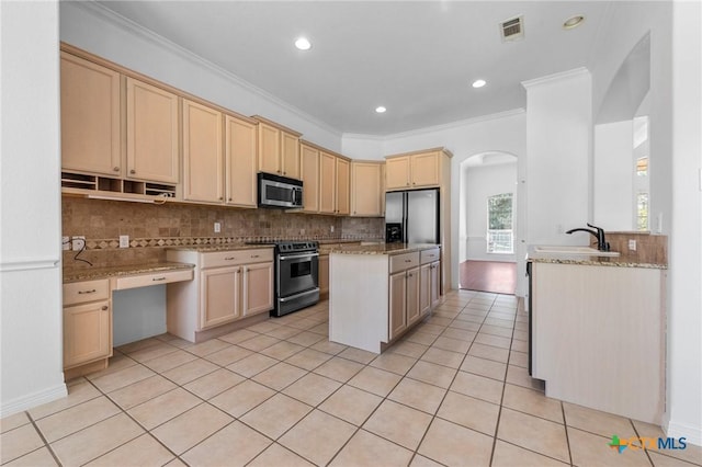 kitchen with light brown cabinets, stainless steel appliances, a sink, visible vents, and backsplash