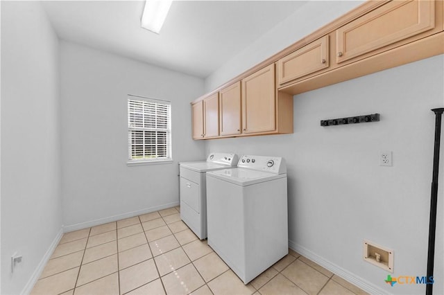 clothes washing area with cabinet space, washer and clothes dryer, baseboards, and light tile patterned floors