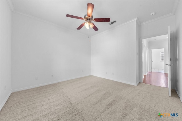 spare room with ornamental molding, baseboards, visible vents, and carpet flooring