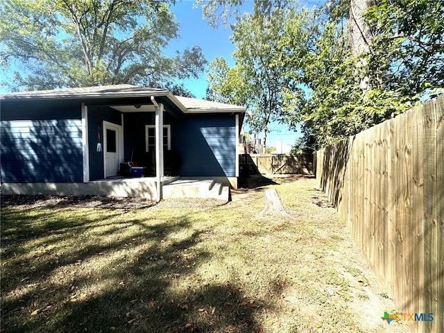 view of side of home featuring a patio and a yard