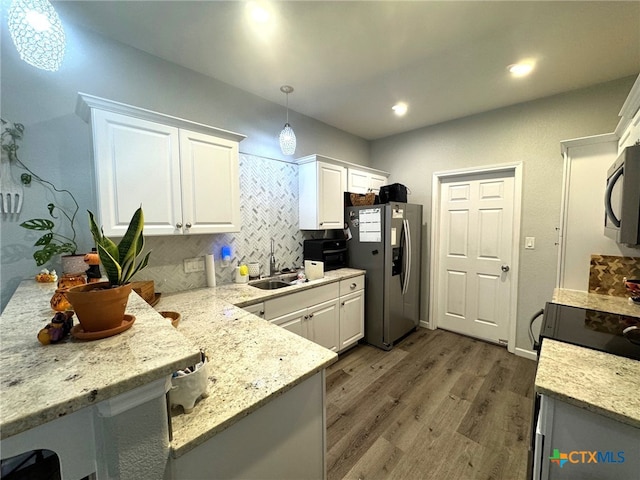 kitchen featuring appliances with stainless steel finishes, pendant lighting, sink, white cabinets, and dark wood-type flooring