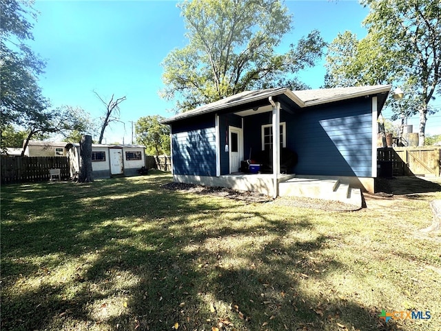 rear view of house featuring a lawn and a patio