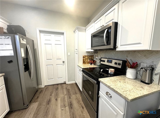 kitchen with light hardwood / wood-style floors, white cabinetry, and appliances with stainless steel finishes