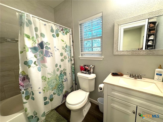 full bathroom with toilet, vanity, hardwood / wood-style floors, and shower / bath combo with shower curtain