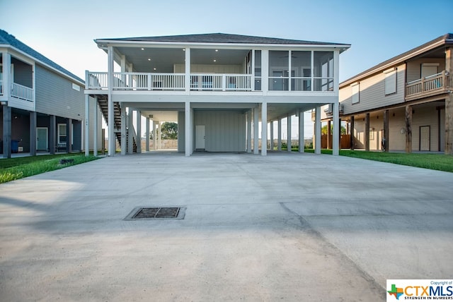 raised beach house featuring a sunroom and a carport