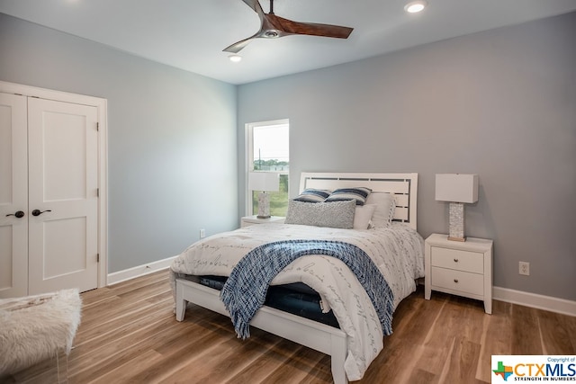 bedroom featuring a closet, hardwood / wood-style floors, and ceiling fan