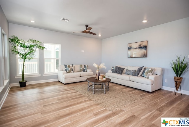 living room featuring ceiling fan and light hardwood / wood-style flooring