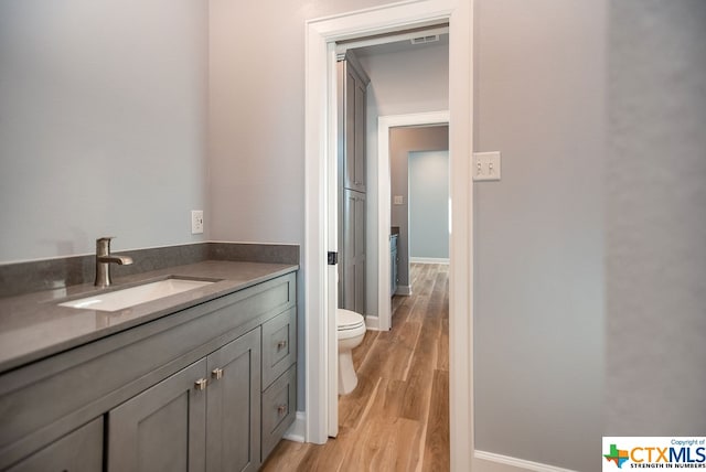 bathroom featuring hardwood / wood-style floors, vanity, and toilet