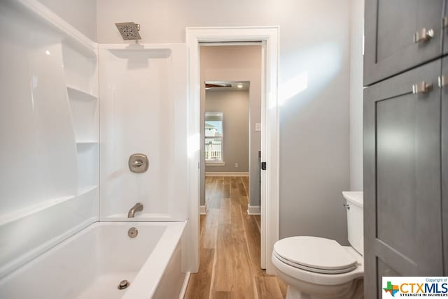 bathroom featuring hardwood / wood-style floors, shower / tub combination, and toilet