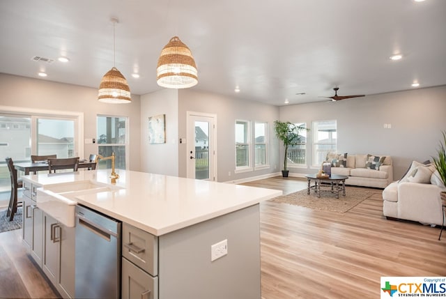 kitchen with dishwasher, hanging light fixtures, gray cabinets, and light hardwood / wood-style flooring