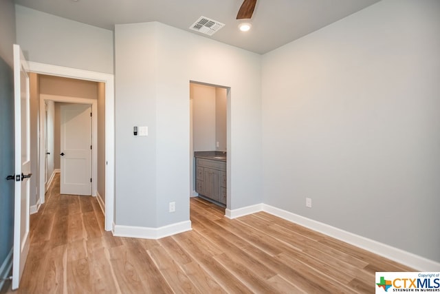 unfurnished bedroom featuring light wood-type flooring and ensuite bath