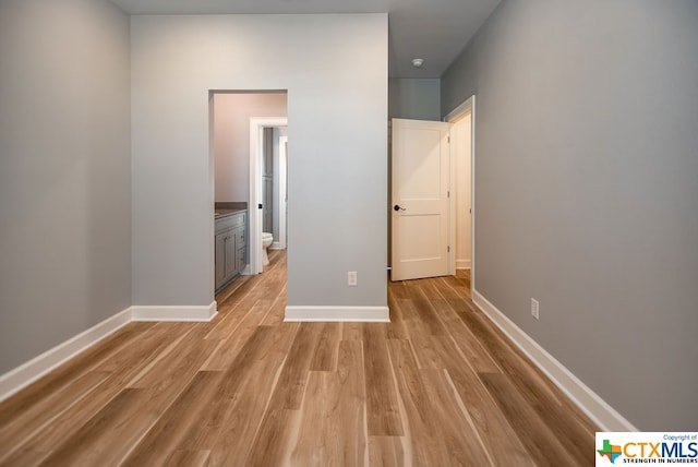 interior space with ensuite bathroom and light hardwood / wood-style flooring