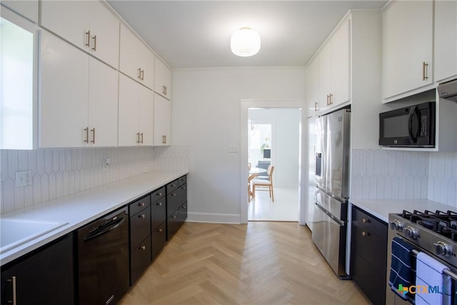 kitchen with light countertops, decorative backsplash, and black appliances