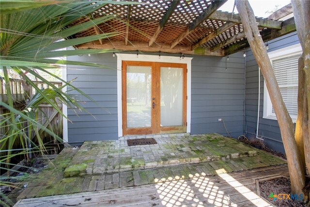 property entrance featuring a patio and a pergola
