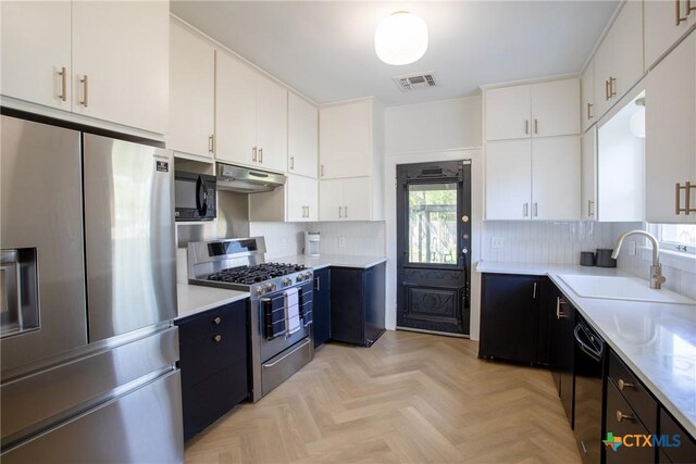 kitchen featuring white cabinets, light countertops, under cabinet range hood, visible vents, and black appliances
