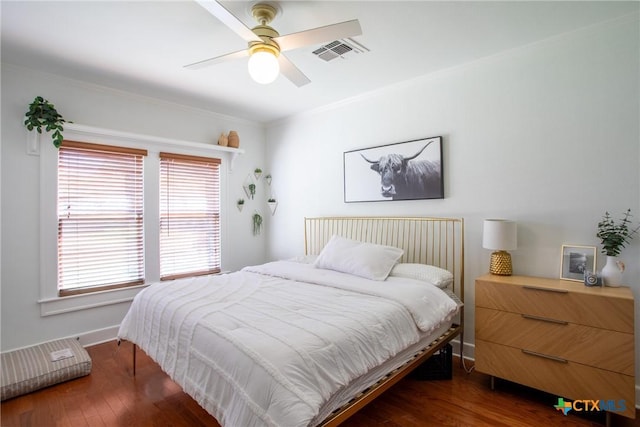 bedroom with ornamental molding, dark wood-style floors, ceiling fan, and visible vents