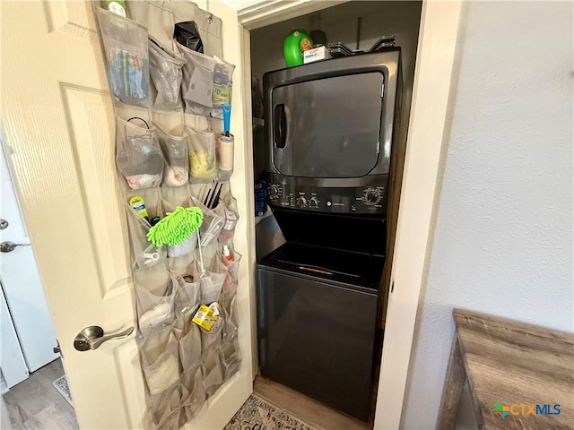 clothes washing area featuring stacked washer and clothes dryer