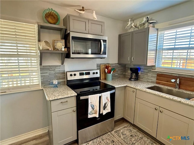 kitchen featuring stainless steel appliances, sink, a wealth of natural light, and backsplash