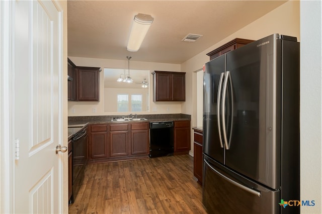 kitchen featuring dark hardwood / wood-style flooring, black appliances, sink, a chandelier, and pendant lighting