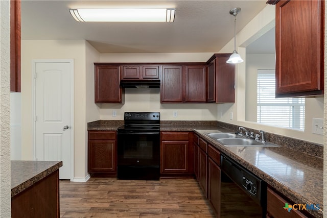 kitchen with black appliances, decorative light fixtures, dark wood-type flooring, and sink