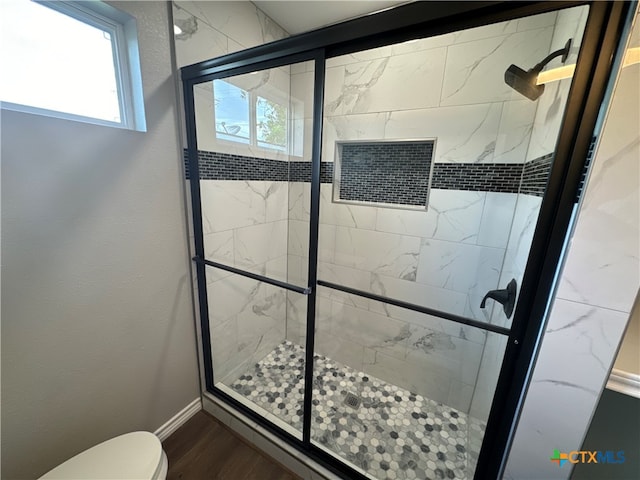 bathroom featuring toilet, an enclosed shower, and hardwood / wood-style floors