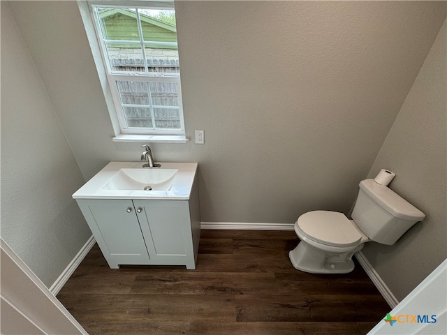 bathroom featuring toilet, vanity, and hardwood / wood-style floors