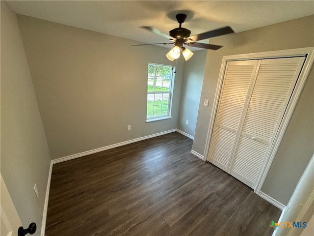 unfurnished bedroom with dark hardwood / wood-style flooring, ceiling fan, and a closet