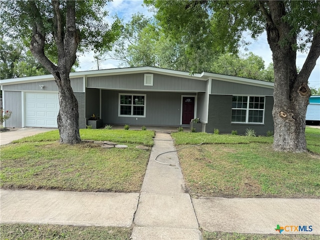 ranch-style house featuring a garage, cooling unit, and a front yard