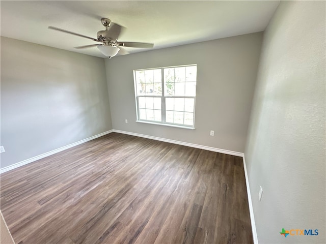 spare room with dark wood-type flooring and ceiling fan